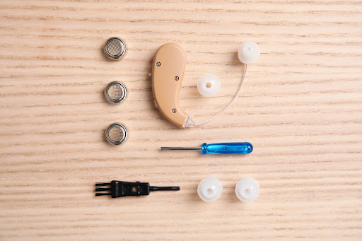 hearing aid components on wooden surface
